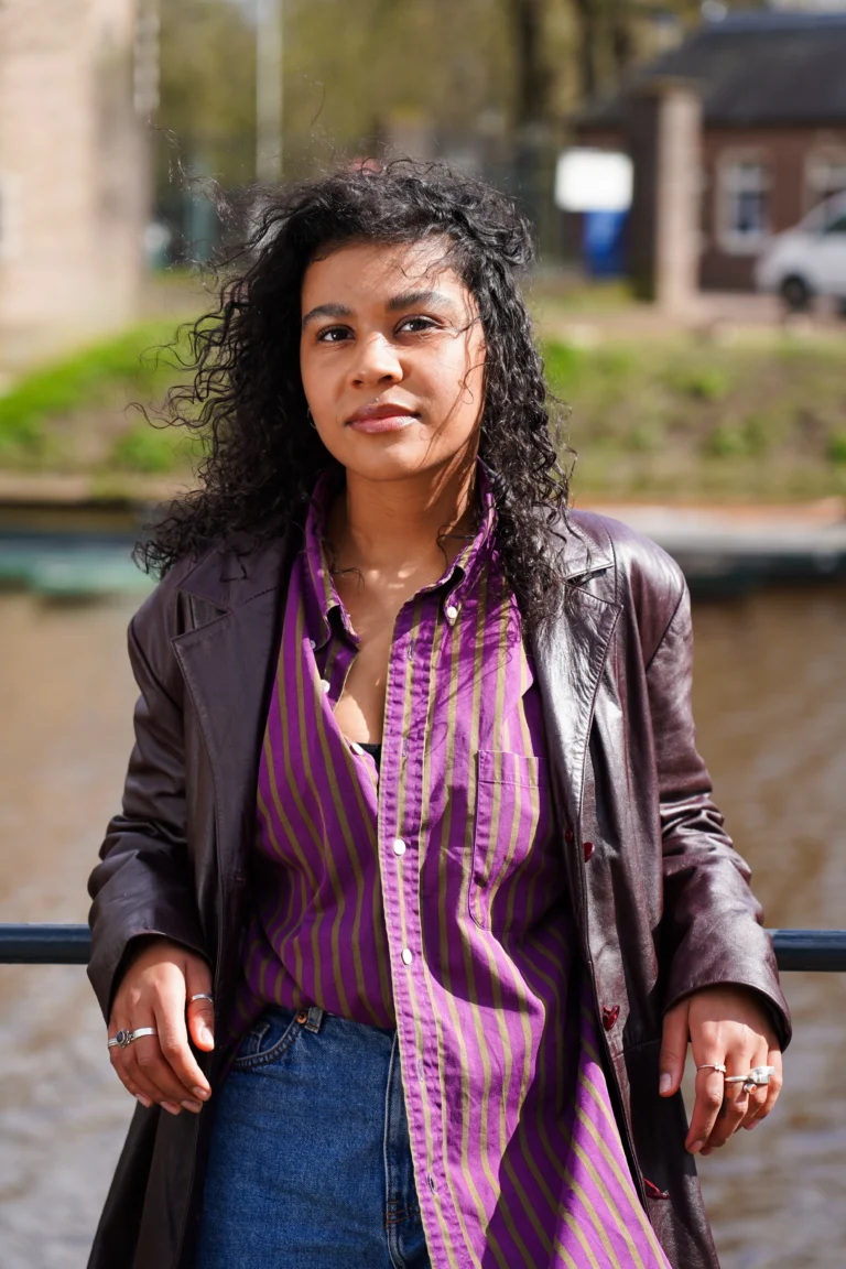 Jonge vrouw leunend tegen een hek bij het Spanjaardsgat in Breda.