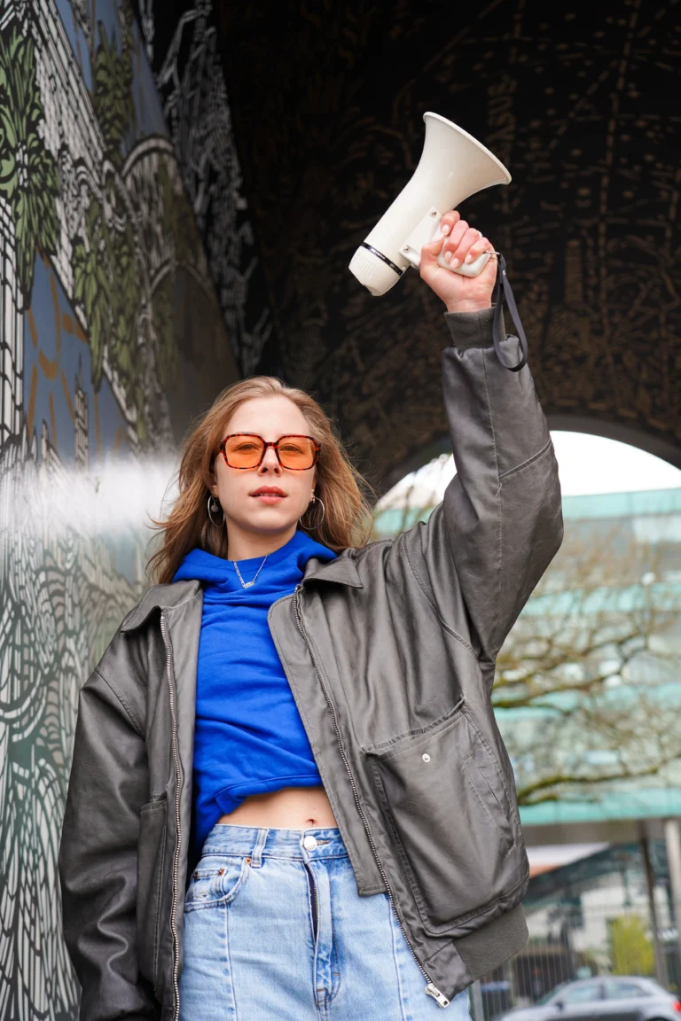 Meisje met blauwe hoodie en leren jack in een van de steegjes van achter de lange stallen in breda.