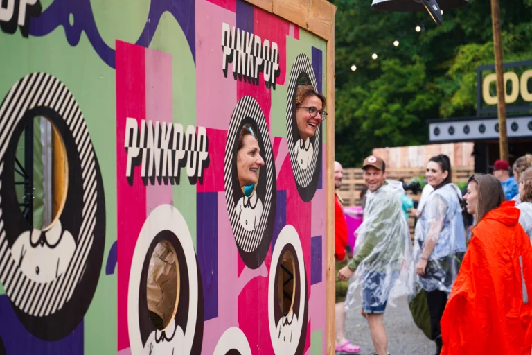 Twee vrouwen steken hun hoofd door een bord op Pinkpop festival 2023.